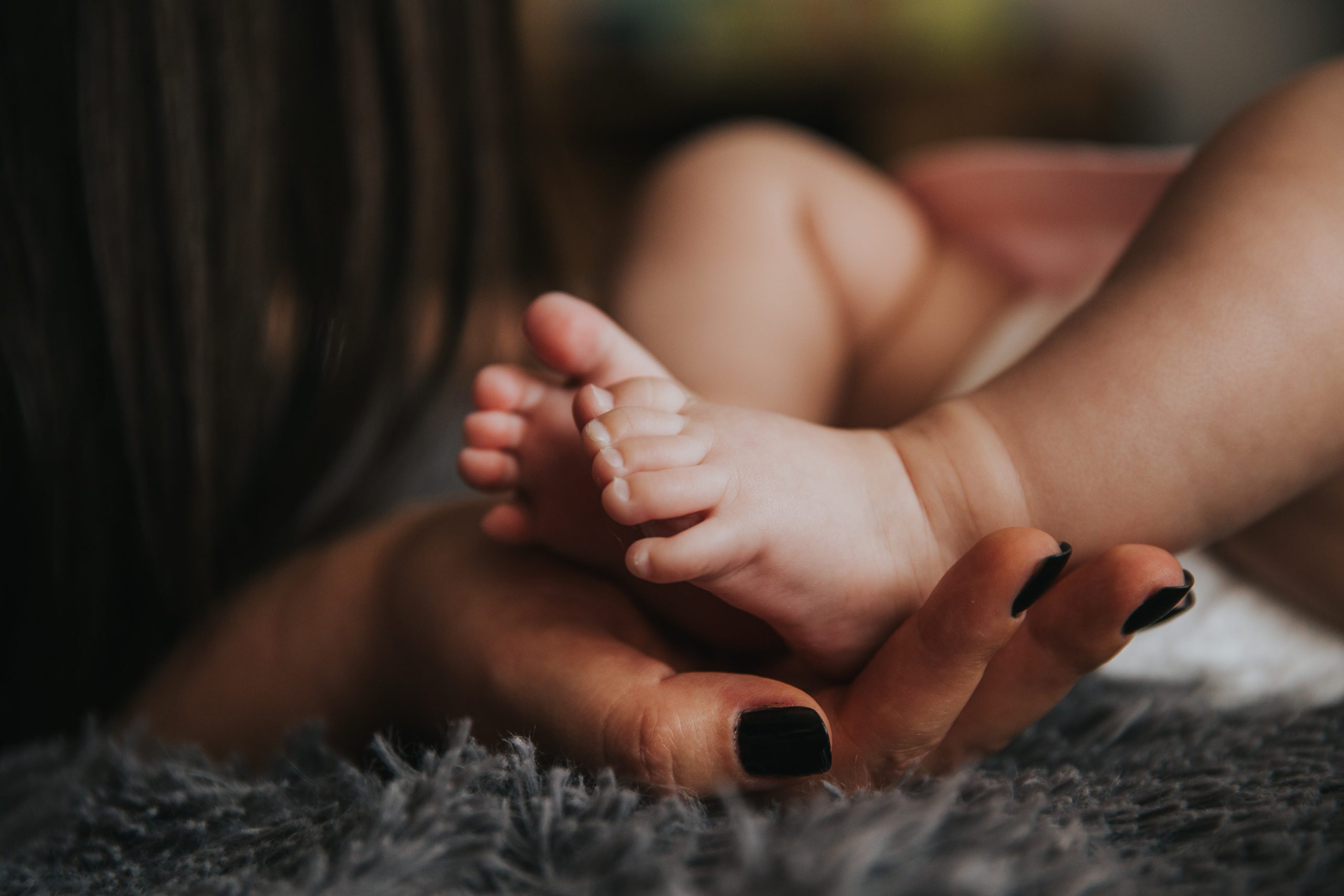 Parent holding baby's feet in her hands